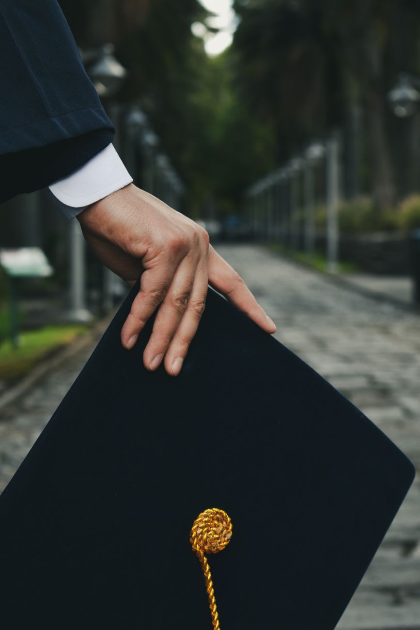 graduate hand holding academic hat