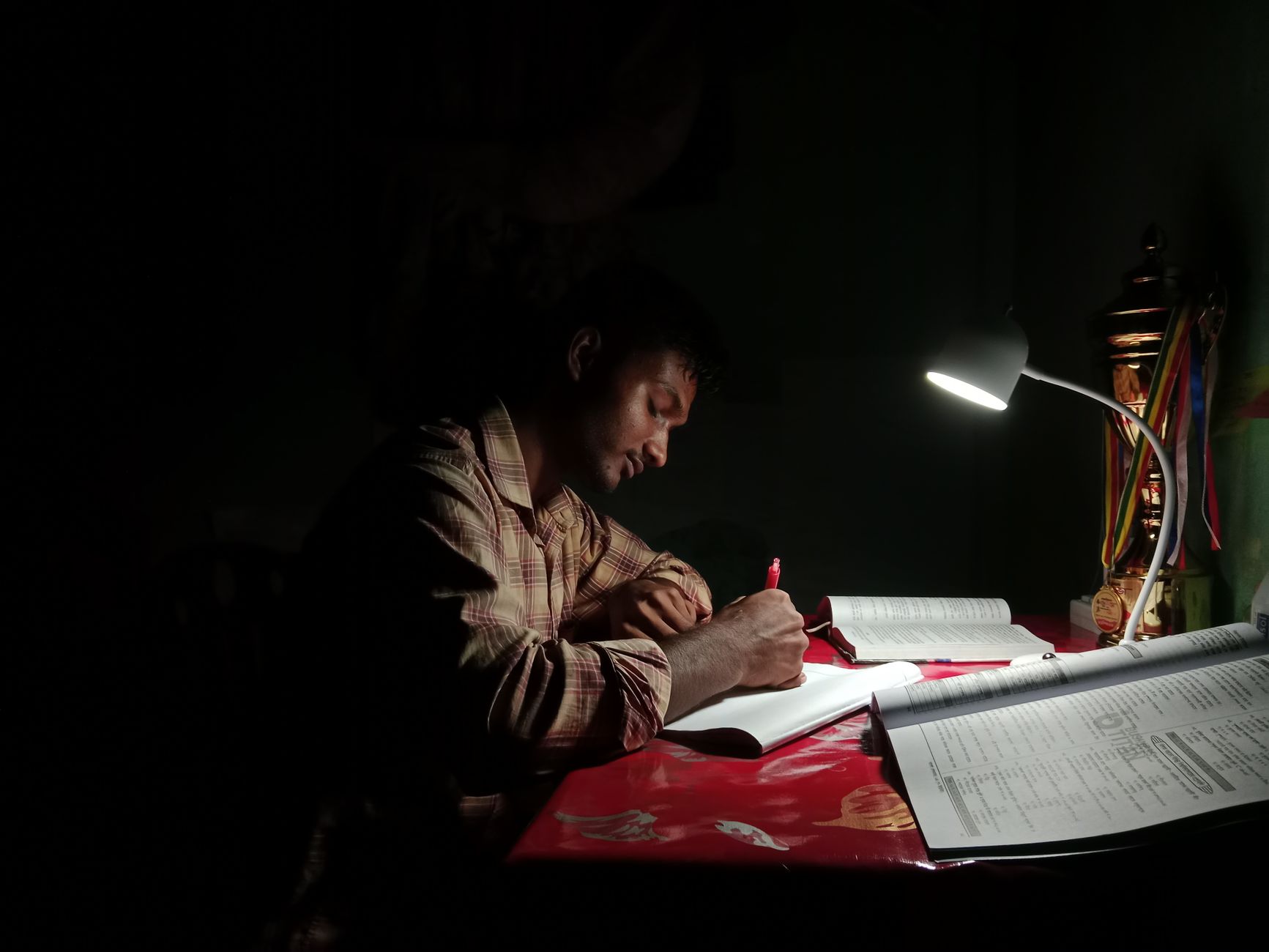 young man studying at night with lamp light
