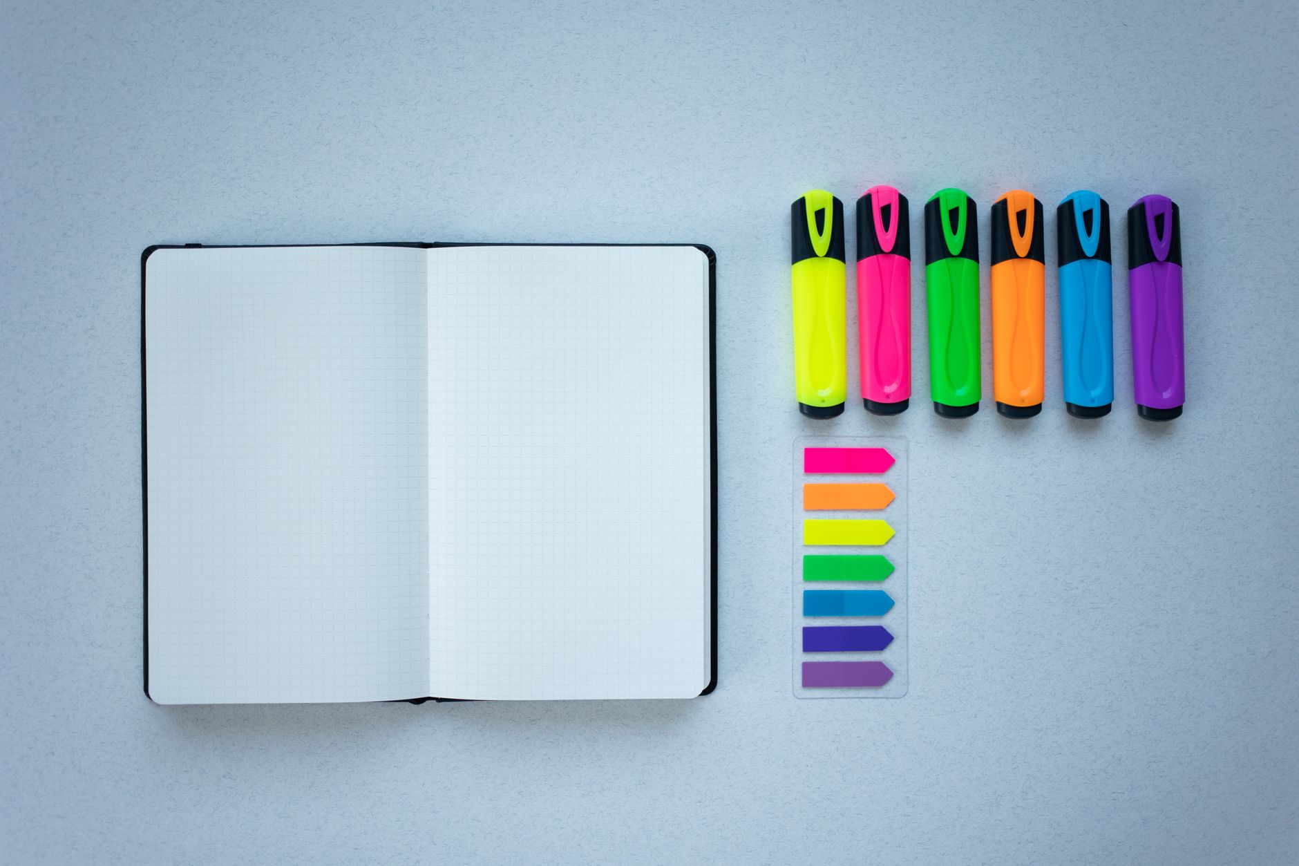 open notebook beside highlighters