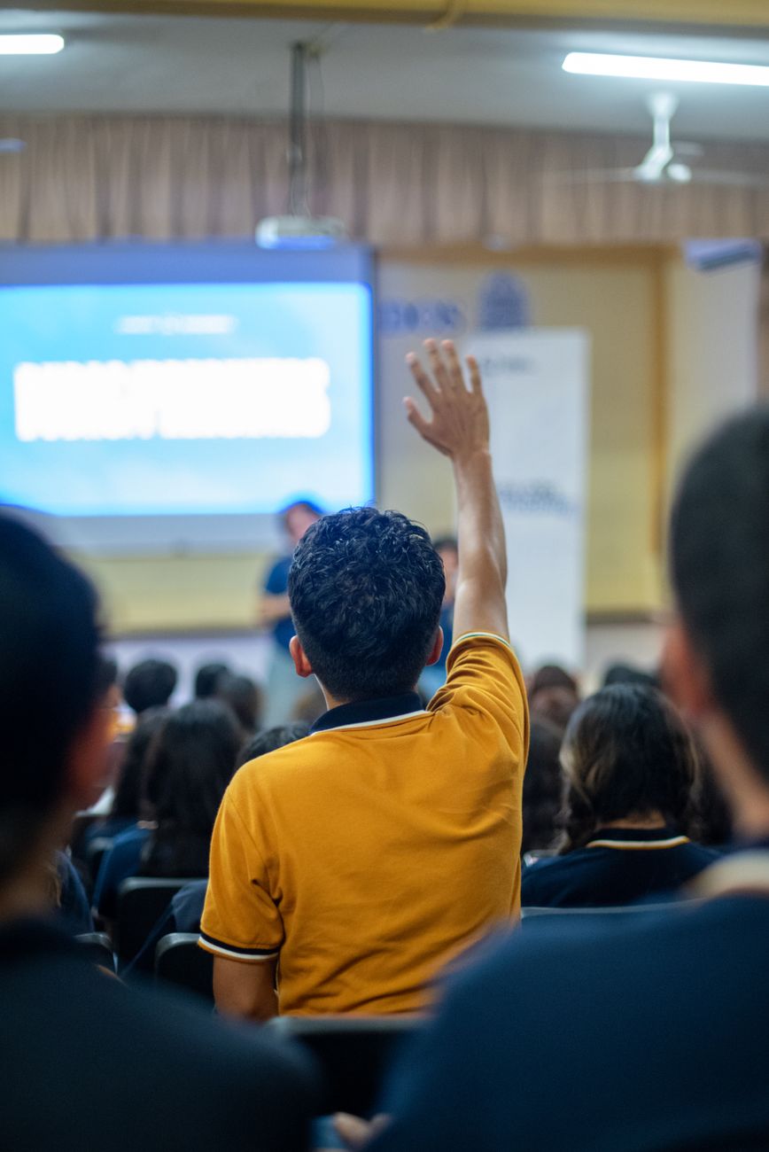 student raising hand in classroom setting