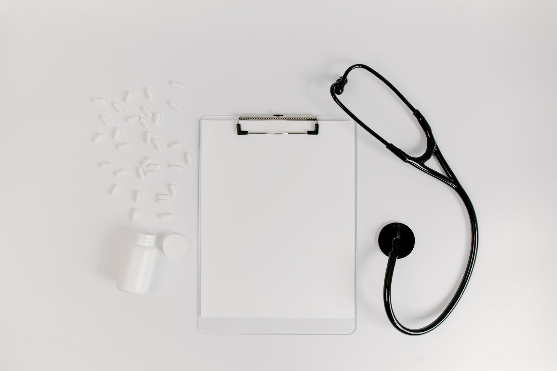 white paper on clipboard beside black stethoscope